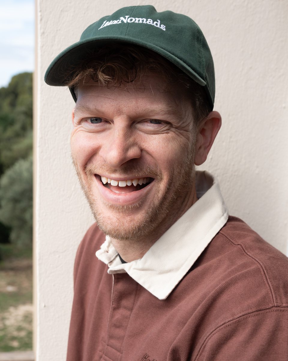 Outdoor portrait of a laughing man in a green cap